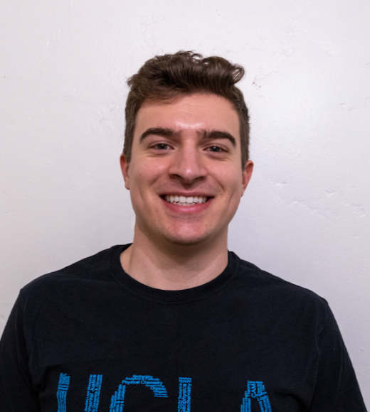 A person smiling, posed for their BruinCard photo